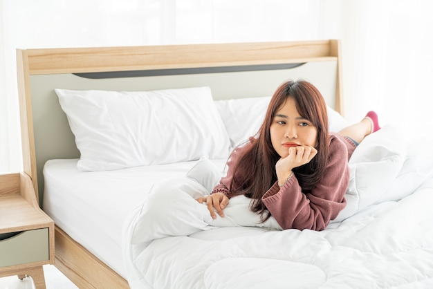 belle donne asiatiche sdraiato sul letto la mattina