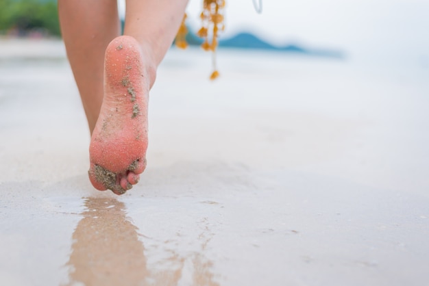 Belle donne asiatiche viaggiano in spiaggia in estate. Sole e vacanza della sabbia del mare.