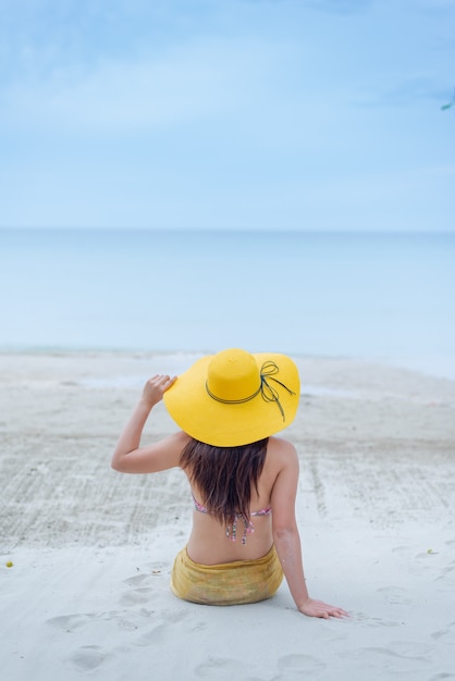 Belle donne asiatiche viaggiano in spiaggia in estate. Sole e vacanza della sabbia del mare.