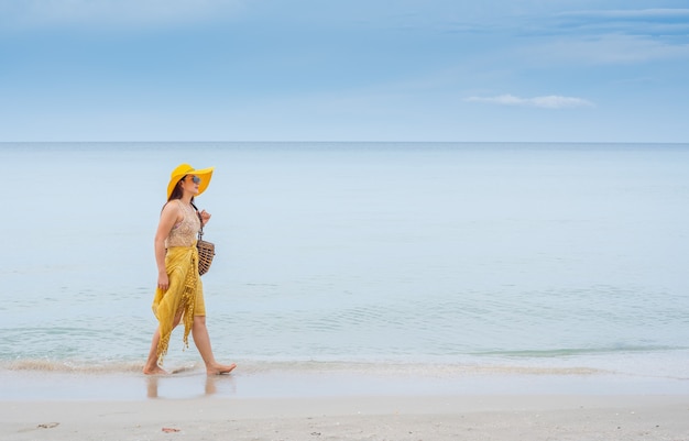 Belle donne asiatiche viaggiano in spiaggia in estate. Sole e vacanza della sabbia del mare.