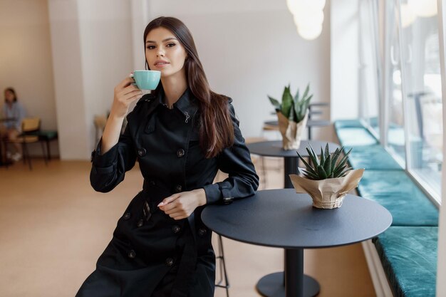 Belle donne in una caffetteria con una tazza di caffè.