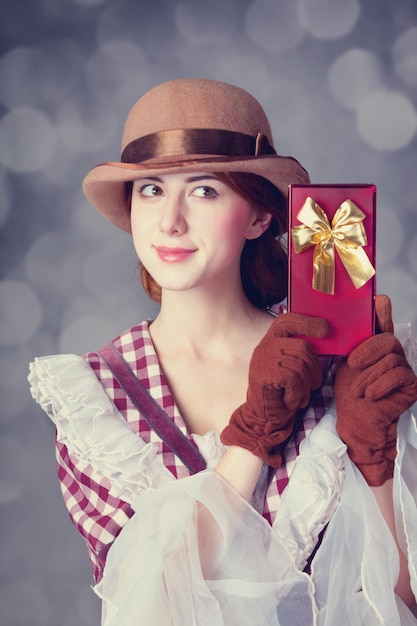 Belle donne rosse con regalo. Foto in stile retrò con bokeh sullo sfondo.