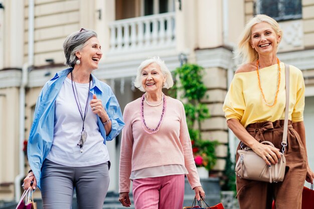 Belle donne senior felici che comperano nel centro urbano