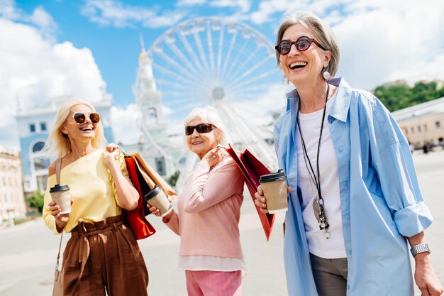 Belle donne senior felici che comperano nel centro urbano