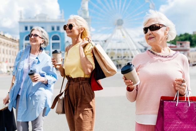 Belle donne senior felici che comperano nel centro urbano