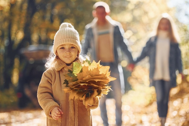 Belle foglie La famiglia felice è insieme nel parco in autunno