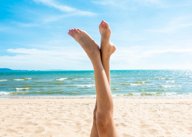 Belle gambe di donna sulla spiaggia