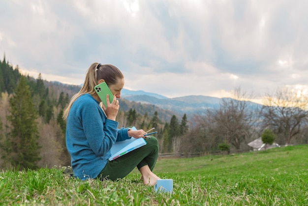 Belle giovani donne lavorano a distanza nella natura in montagna