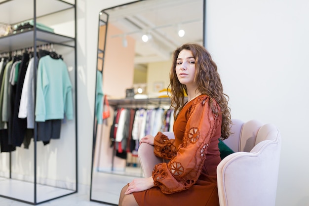 belle giovani donne va a fare la spesa in un negozio di abbigliamento e mostra un vestito in uno showroom durante sconti e saldi