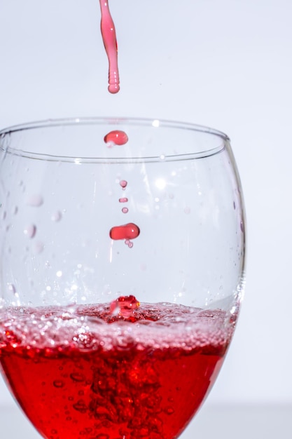 Belle gocce di vino rosso in un bicchiere