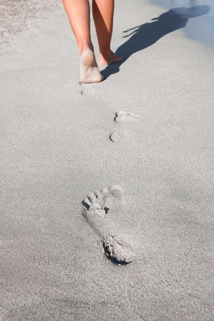 Belle impronte con i piedi sullo sfondo di sabbia