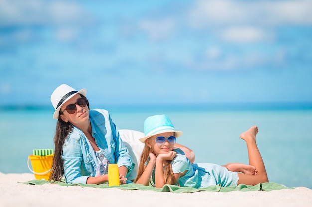 Belle madre e figlia alla spiaggia caraibica che godono delle vacanze estive.