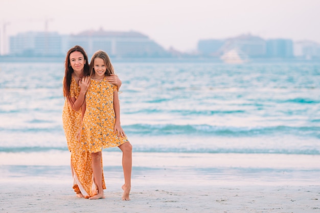 Belle madre e figlia sulla spiaggia godendo le vacanze estive.