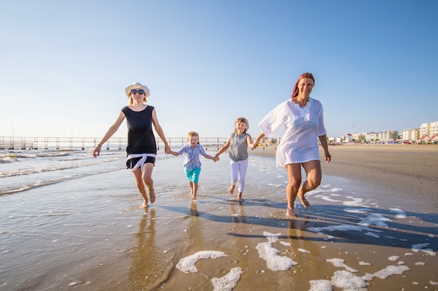 belle mamme stanno giocando con i suoi bambini nel mare