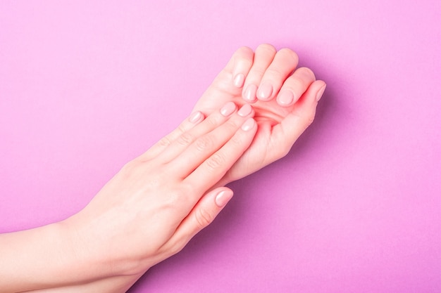 Belle mani femminili che mostrano il concetto di cura fresca e carina di manicure, pelle e unghie