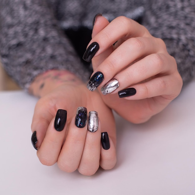 Belle mani femminili con manicure alla moda unghie smalto gel nero