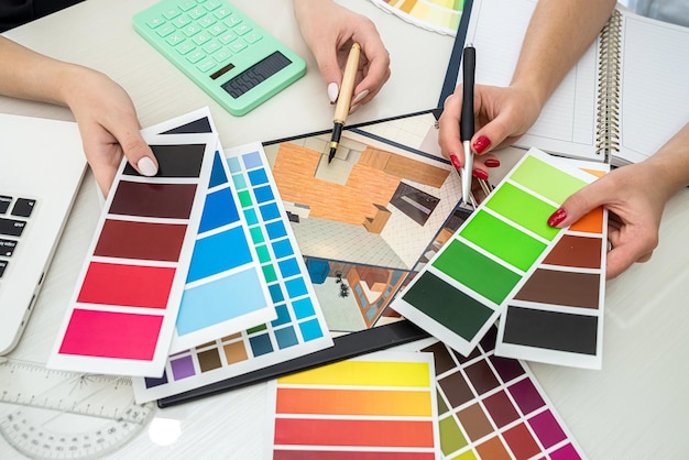 Belle mani femminili con manicure che lavorano con campioni di colore per progettare stanze sul tavolo Concetto di campioni Il concetto di colori Concetto di design