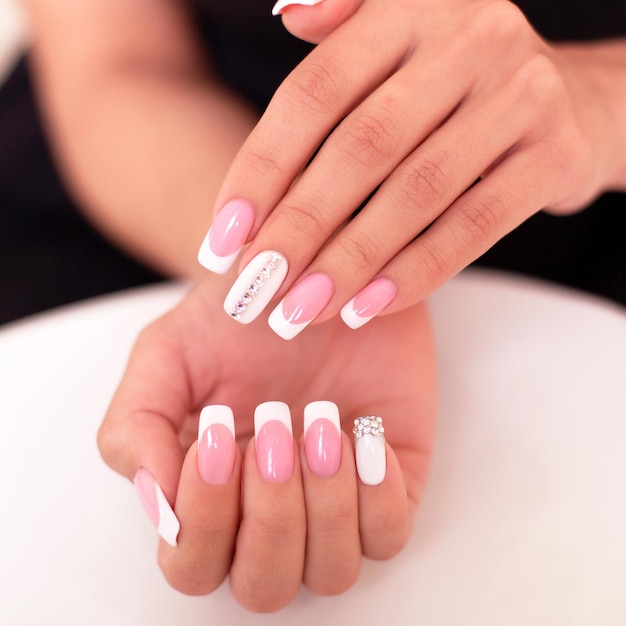 Belle mani femminili con unghie french manicure