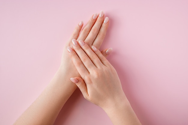 Belle mani femminili su una rosa