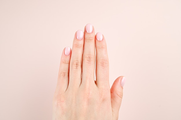 Belle mani femminili sulla superficie beige