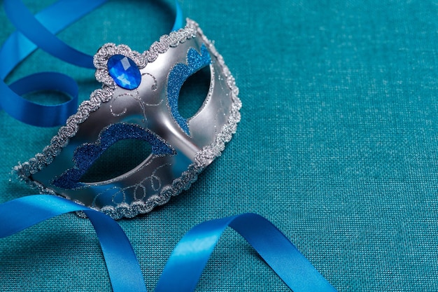 Belle maschere di carnevale con un nastro blu su uno sfondo turchese Purim Mardi Gras
