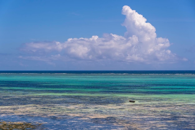 Belle nuvole bianche e cielo blu sopra le onde dell'acqua di mare sull'isola di Zanzibar Tanzania Africa Concetto di viaggio e natura