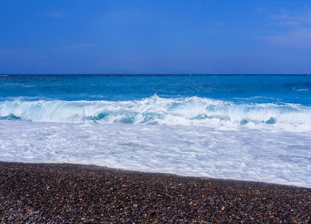 Belle onde di schiuma in una giornata di sole nel Mar Egeo sull'isola di Evia in Grecia