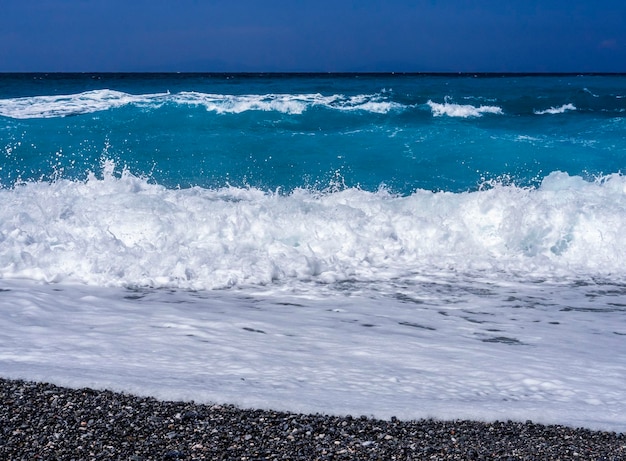 Belle onde di schiuma in una giornata di sole nel Mar Egeo sull'isola di Evia in Grecia