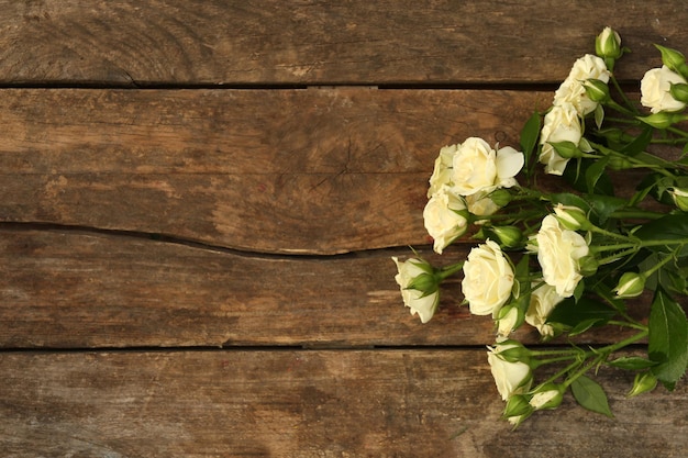 Belle piccole rose su fondo di legno