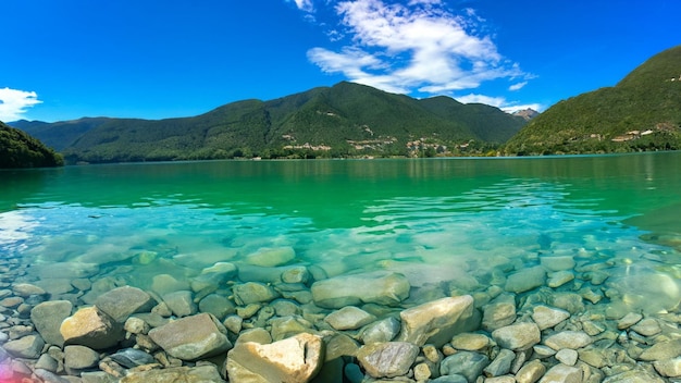 Belle pietre sotto l'acqua turchese di un lago e colline sullo sfondo