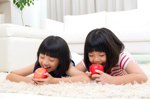 Belle ragazze asiatiche che mangiano mela