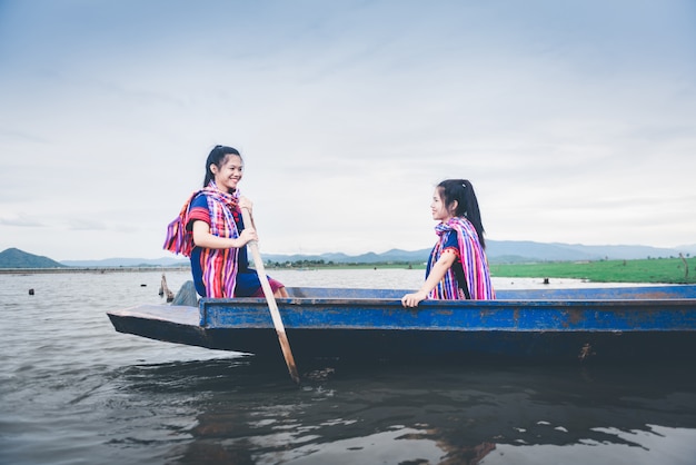 Belle ragazze asiatiche sul peschereccio in lago per pescare pesce alla campagna della Tailandia