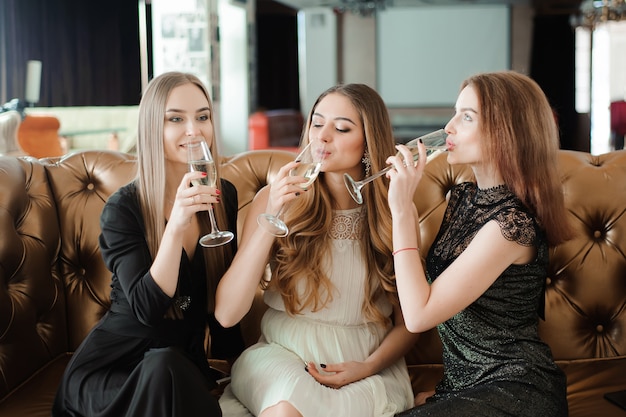 Belle ragazze calde che si divertono alla festa, bevendo champagne