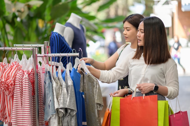 Belle ragazze con le borse della spesa che camminano al centro commerciale.