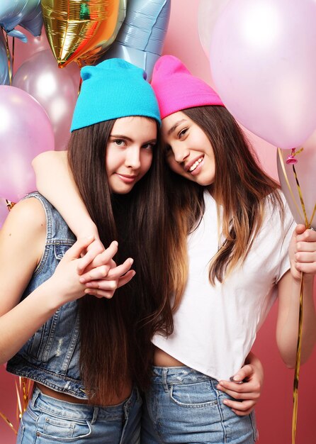 Belle ragazze con palloncini d'aria su sfondo rosa