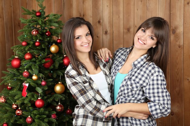 Belle ragazze gemelle vicino all'albero di Natale a casa