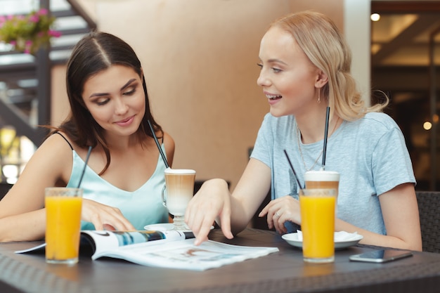 belle ragazze giovani seduti al tavolo in caffetteria