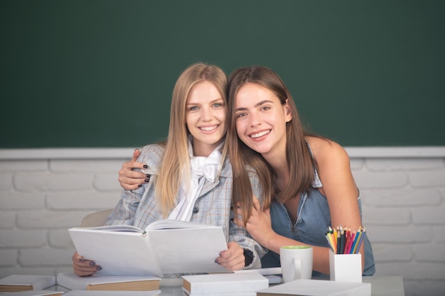 Belle ragazze studentesse che si abbracciano e si abbracciano in classe al college scolastico