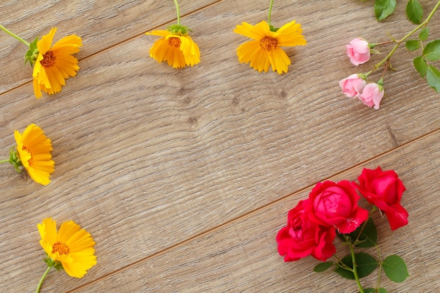 Belle rose e fiori di calendula sullo sfondo di legno. Concetto di fare un regalo in vacanza. Vista dall'alto.