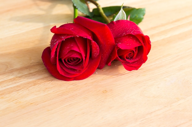 Belle rose rosse sullo scrittorio di legno