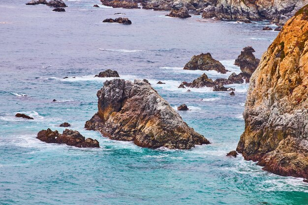 Belle scogliere ruvide aerea dell'Oceano Pacifico che si schianta contro la dura costa californiana