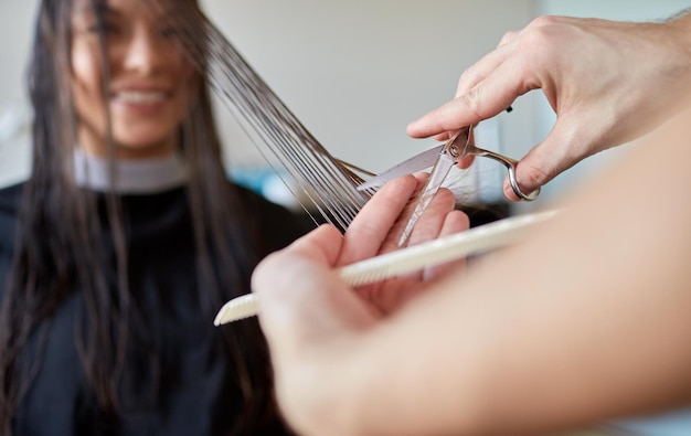 bellezza, acconciatura e concetto di persone - felice giovane donna e parrucchiere mani con forbici e pettine per tagliare le punte dei capelli al salone