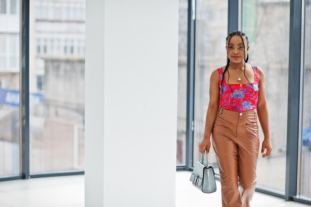 Bellezza afro-americana modello moda donna brasiliana posa al coperto con borsetta.