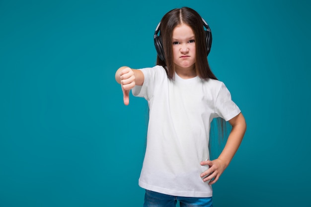 Bellezza bambina in t-shirt e auricolari con i capelli lunghi