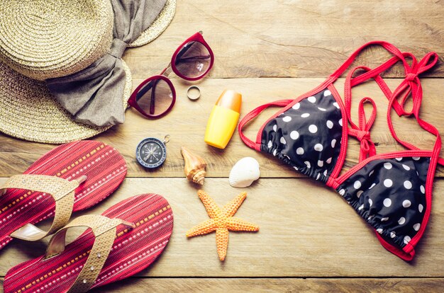 Bellezza bikini colorato e accessori sul pavimento di legno per viaggio in estate