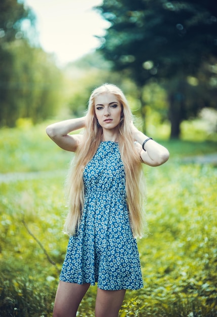 Bellezza bionda con capelli lunghi e lucenti La donna è alla moda in un vestito blu Moda