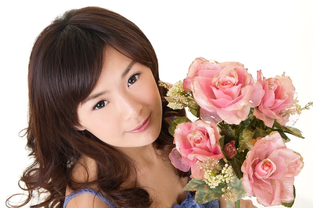Bellezza con le rose, ritratto del primo piano della ragazza asiatica sulla parete bianca.
