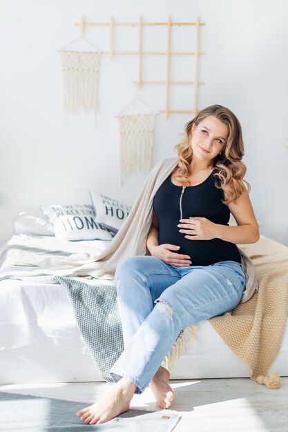 bellezza donna incinta sorride misteriosamente guarda da parte i sogni di un futuro bambino
