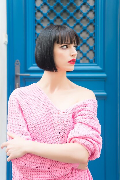 Bellezza e moda, donna parigina con eleganti capelli corti castani e labbra rosse all'aperto su sfondo blu, Francia