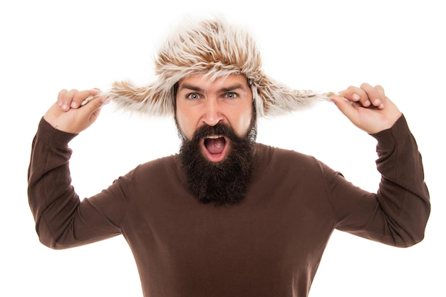 Bellezza maschile. ritratto di uomo gridante. uomo maturo con la barba nel cappello con paraorecchie. cura dei capelli della barba. pantaloni a vita bassa isolati su bianco. ragazzo fiducioso con i baffi indossa un cappello caldo. moda invernale maschile.